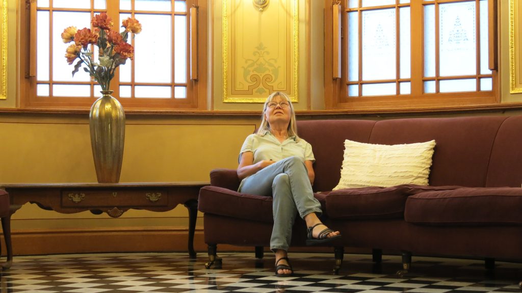 Inger tittar upp på taket i trapphuset på hotell Knaust.